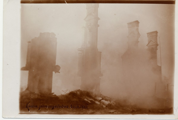 Schwarzes und weißes Foto eines baufälligen Stadtgebäudes, das von Text umrahmt wird und bröckelnde Wände und zerbrochene Fenster zeigt.