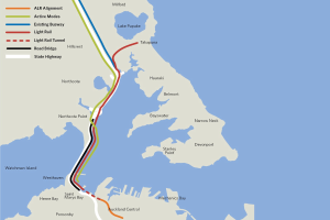 Eine detaillierte Stadtkarte mit einer roten Linie, die die vorgeschlagene Bahnroute markiert, einschließlich beschrifteter Haltestellen und umgebender Gebiete.