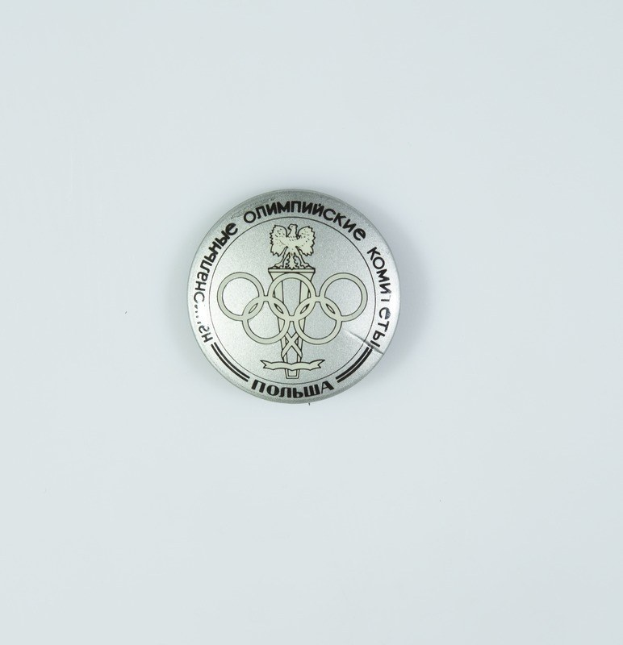 Eine runde Silbermedaille mit dem Olympischen Logo und Text auf einem weißen Hintergrund.