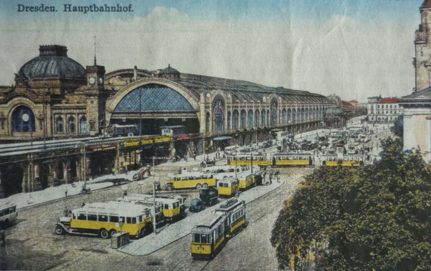 Schwarz-weiß-Postkarte des Dresdner Hauptbahnhof-Bahnhofs in Dresden, Deutschland, zeigt eine belebte Straßen Szene mit Fahrzeugen, Fußgängern, Bäumen, Gebäuden und einem bewölkten Himmel.