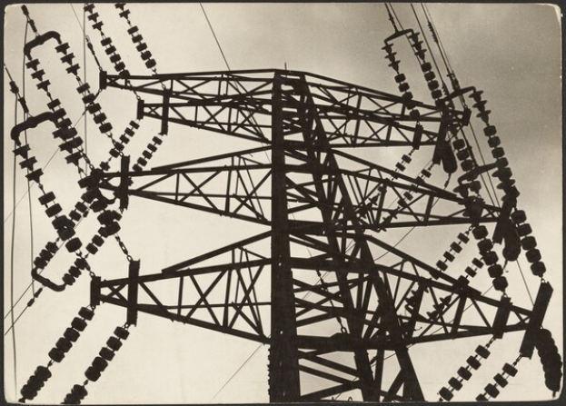 Schwarz-weiß-Foto eines Hochspannungsmasten mit Drähten vor einem Himmel und Text unten.