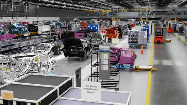 Großes Fabrikgebäude mit mehreren Autos auf einer Fertigungsstraße, Metallstrukturen an den Seiten, eine Wand im Hintergrund und Deckenbeleuchtung, wahrscheinlich eine Volkswagen-Fabrik in Deutschland.
