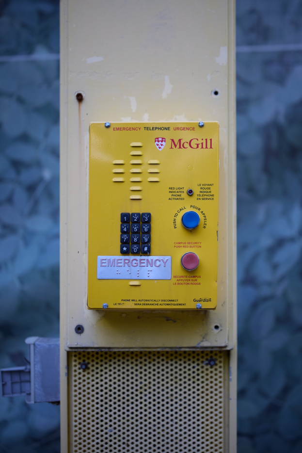 Gelber Notruf an einer Gebäudewand mit Tasten und Text für Notrufe.