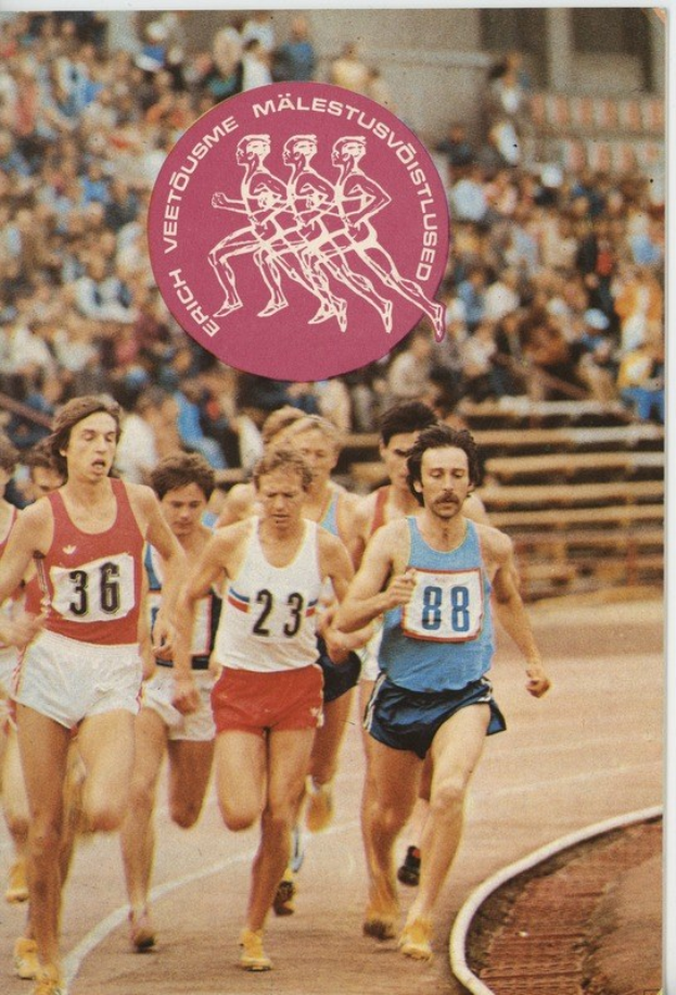 Gruppe von Männern, die auf einer Laufbahn während eines Rennens laufen, mit Zuschauern im Hintergrund.