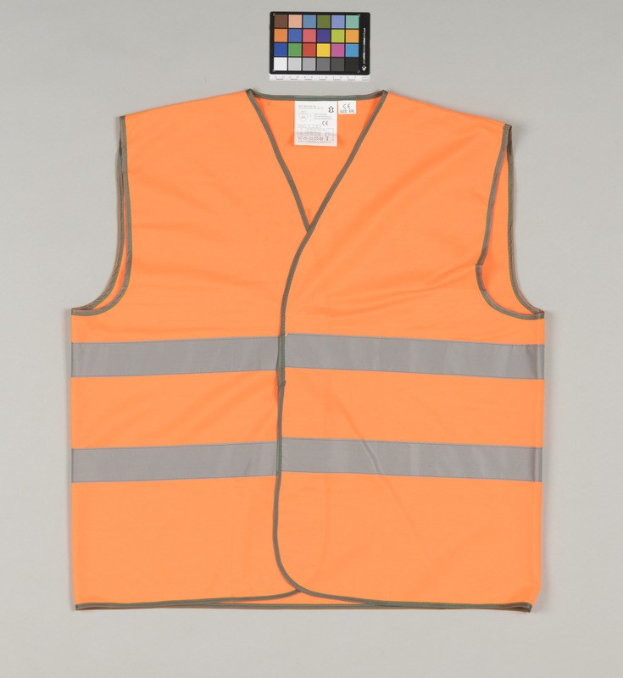 Leuchtend orangefarbene Sicherheitsweste mit reflektierenden Streifen und einem Anhänger auf einem grauen Hintergrund.