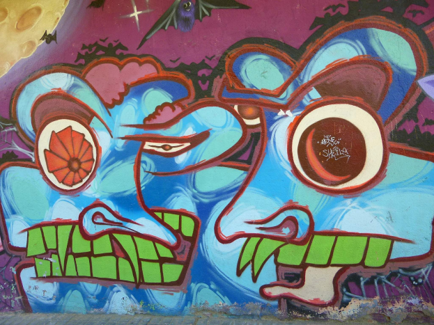 Ein farbenfrohes, buntes Wandgemälde mit Graffiti-Art an der Seite eines Gebäudes