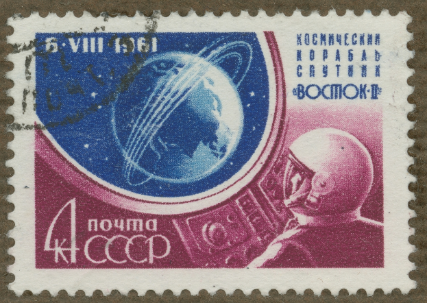 Eine Briefmarke mit einem Mann im Weltraumanzug mit Helm, der eine entschlossene Miene zeigt, umgeben von der fettgedruckten Text 'Marke' in weißer Schrift.