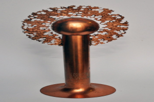 Eine zylindrische Kupfer-Tesla-Spule mit metallischem Glanz auf einem weißen Hintergrund.