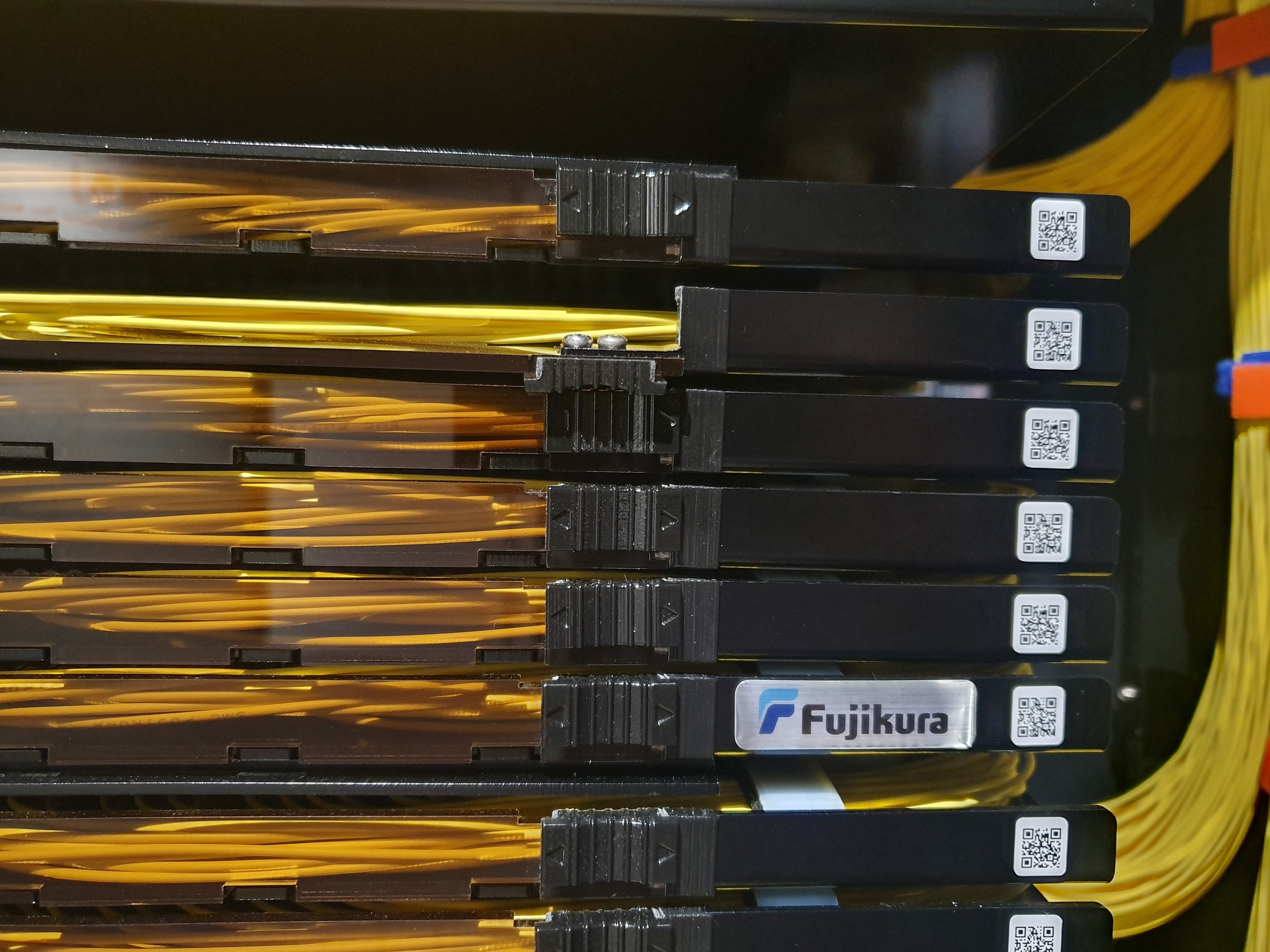 Nahaufnahme eines Serverschranks in einem Rechenzentrum mit angeschlossenen elektronischen Geräten und Netzwerkkabeln.