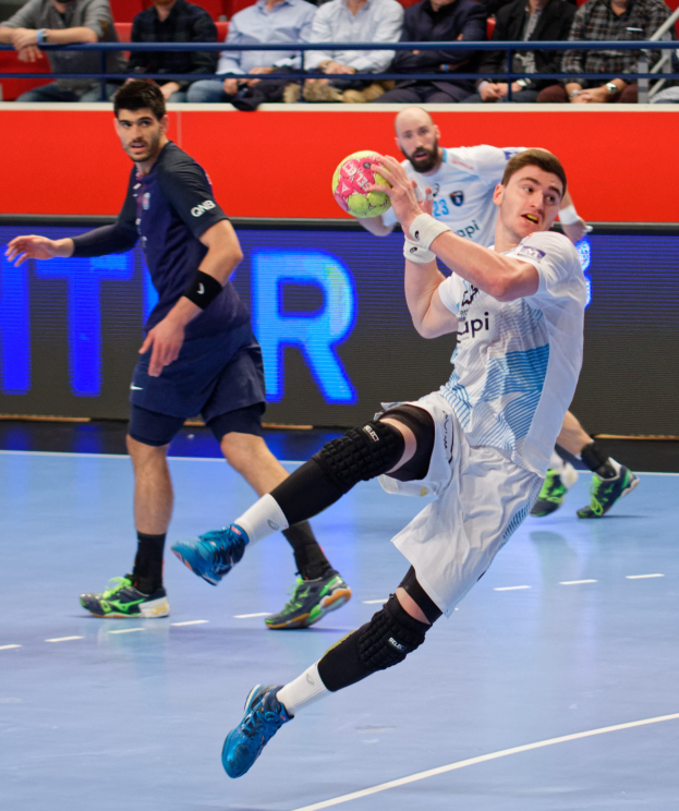 Gruppe von Männern, die Handball auf einem Court während der Futsal-Weltmeisterschaft 2019 spielen, mit Zuschauern im Hintergrund.