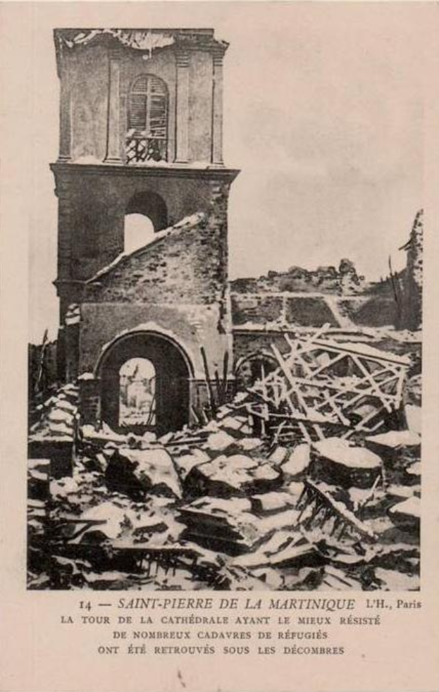 Schwarz-weiß-Foto eines durch ein Feuer zerstörten Gebäudes, das in Trümmern liegt, mit verstreuter Trümmer und Text unten.