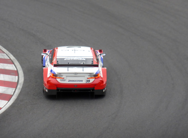 Roter und weißer Toyota Supra GT3-Sportwagen auf einer Rennstrecke, mit dem Text "Toyota Supra GT3" auf der Seite.