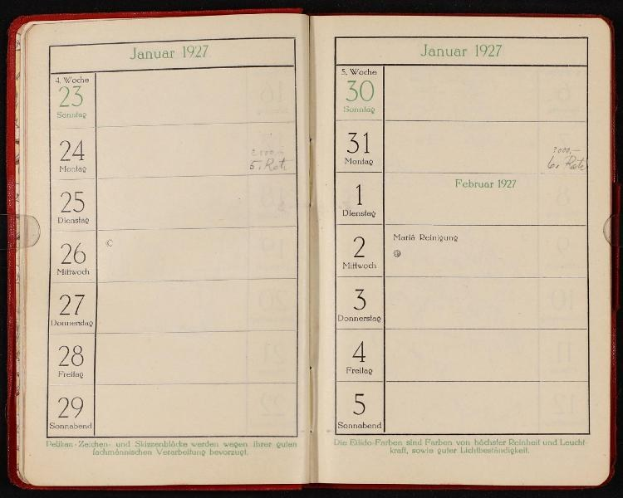 Offenes deutsches Tagebuch von 1927 mit Kalender oben, vor dunklem Hintergrund dargestellt.
