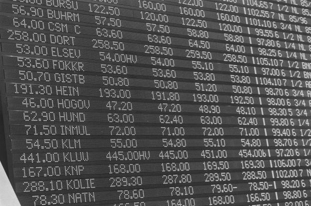 Schwarz-weiß-Foto eines elektronischen Aktien-Tickers mit aktuellen Aktienkursen und Text.