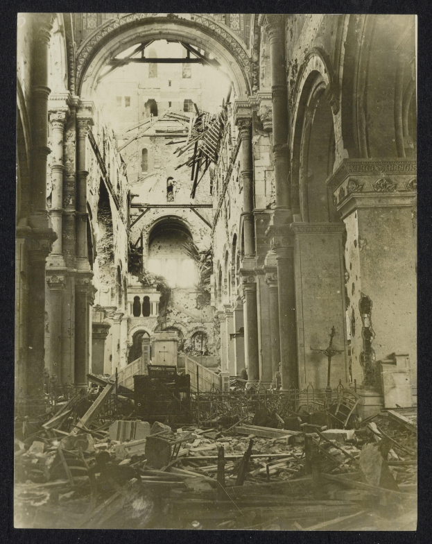 Ein altes Schwarz-Weiß-Foto eines zerstörten Kircheninneren mit zerbrochenem Holz auf dem Boden und Säulen und Bögen im Hintergrund.